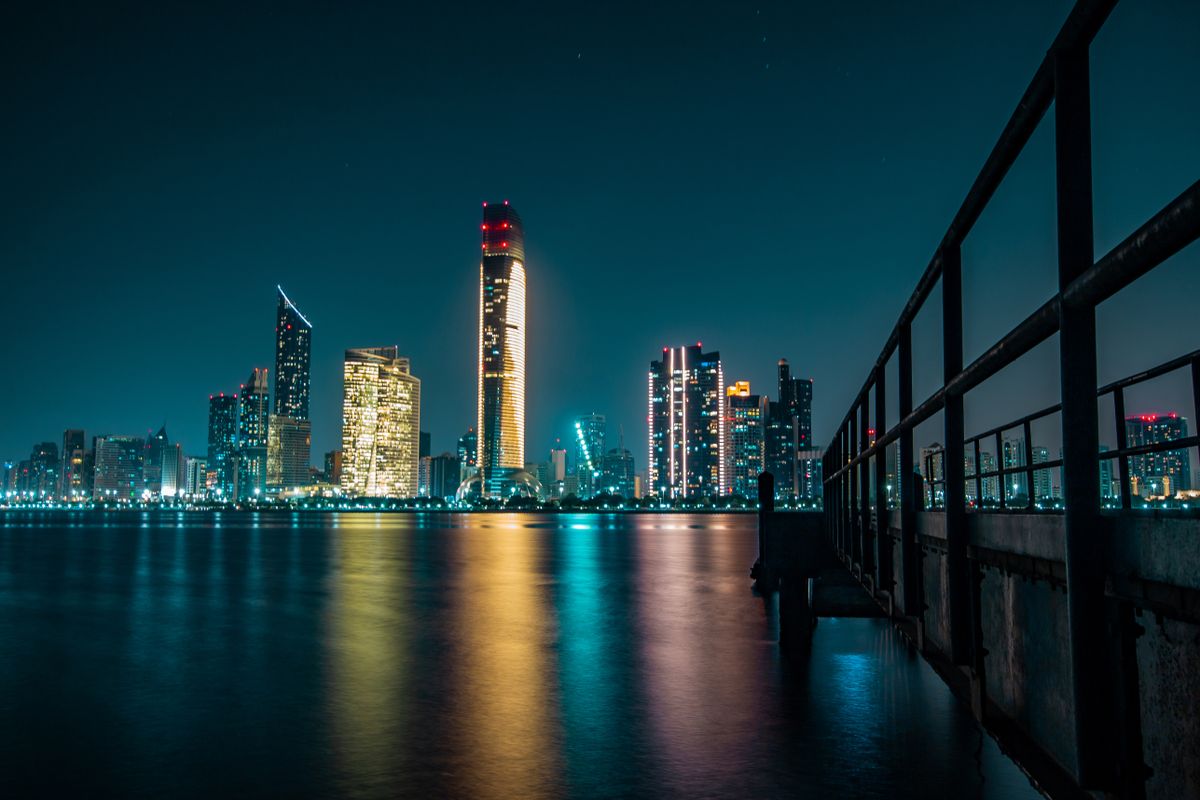 Abu Dhabi skyline at night reflected on the water