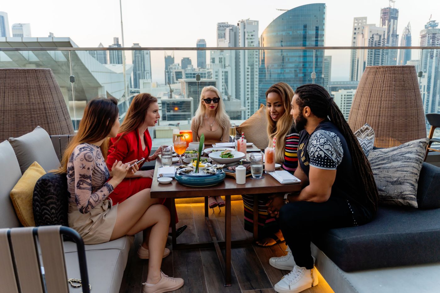 Guests on a Dubai rooftop with the skyline behind